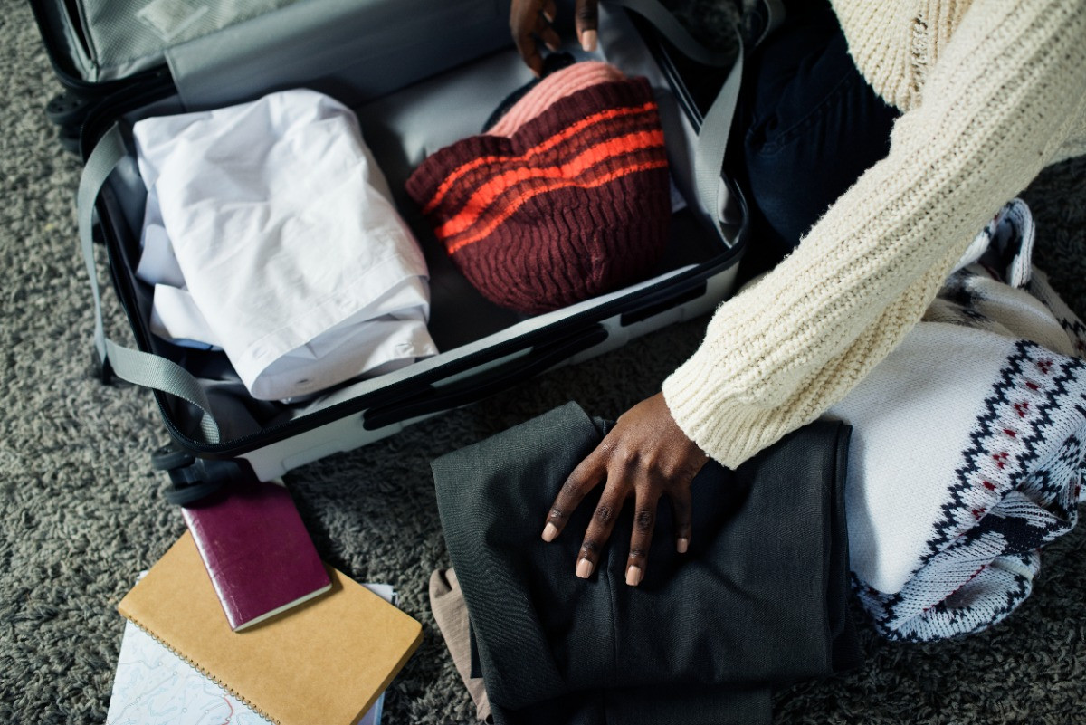 Woman in a cream sweater packing for cold climate RV roadtrip